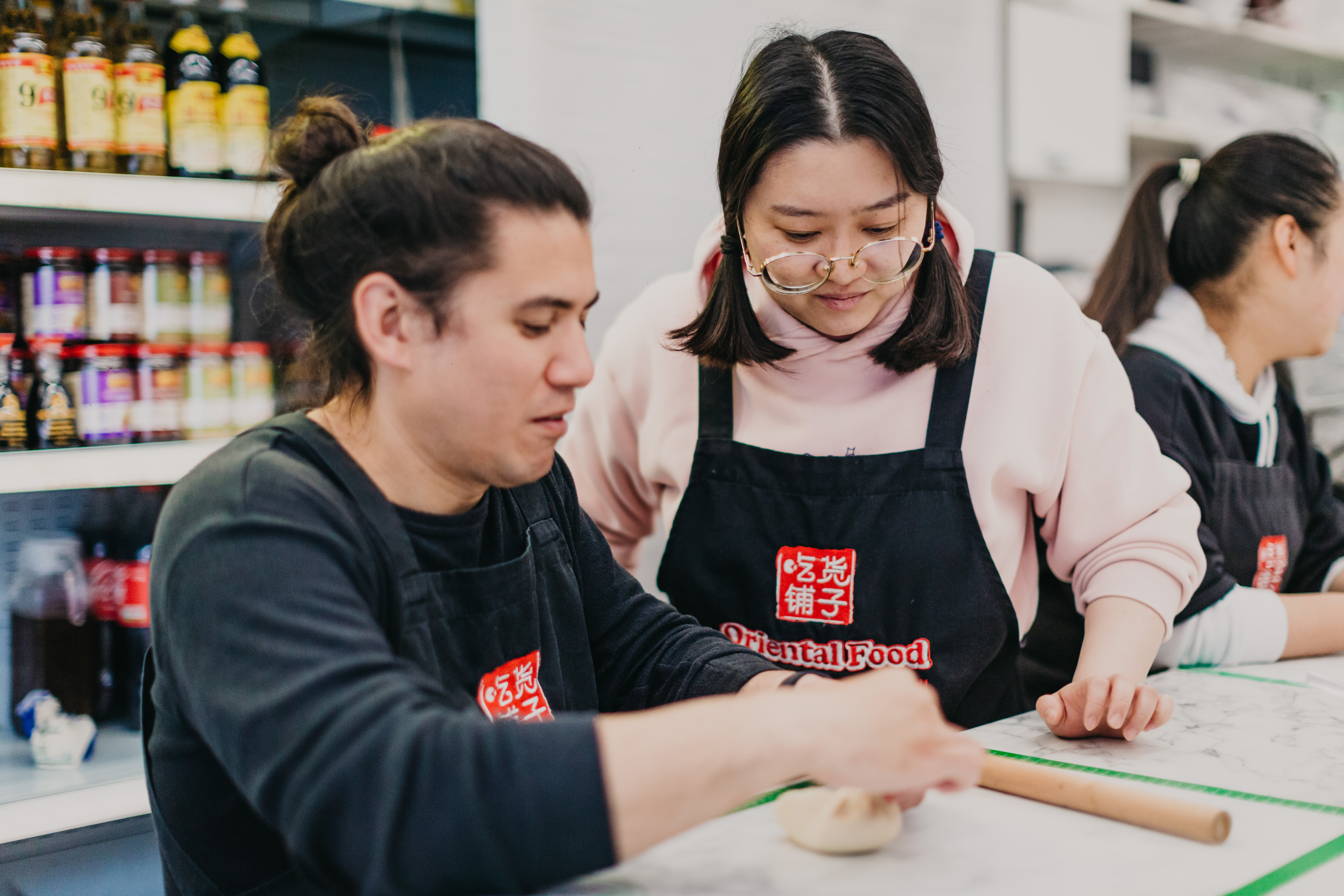 A teacher helping a student at a cooking class
